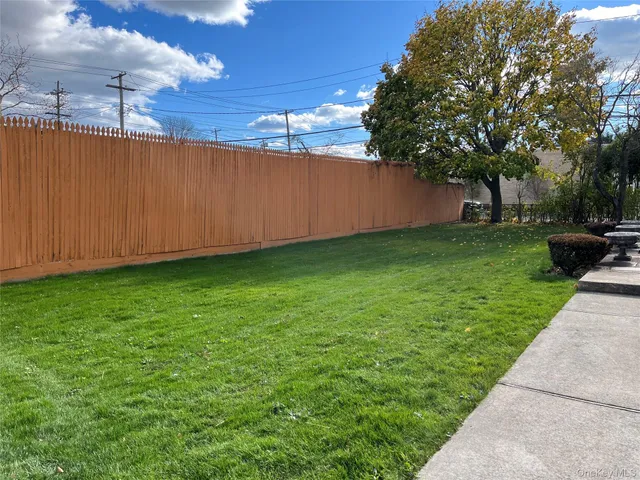 a view of a backyard with potted plants and large trees