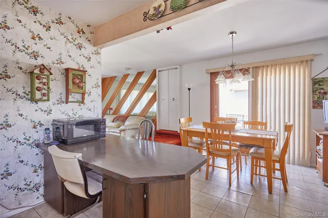 a dining room with furniture a large window and a chandelier