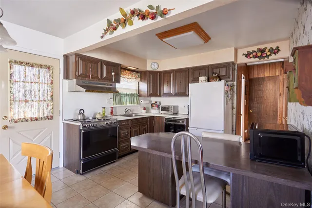 a kitchen with stainless steel appliances granite countertop a refrigerator stove microwave and sink