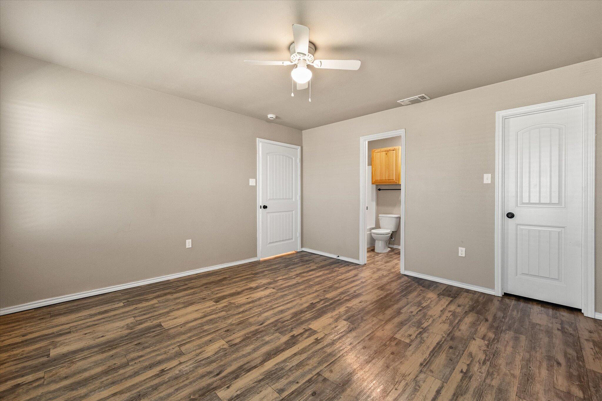 7412 5th Street, Unit 1 Lubbock, TX 79416 - Photo 11 of 16 an empty room with wooden floor and ceiling fan