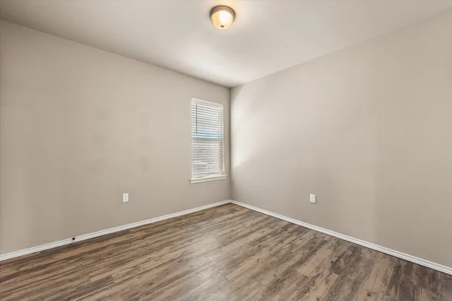 a view of a livingroom with wooden floor and window