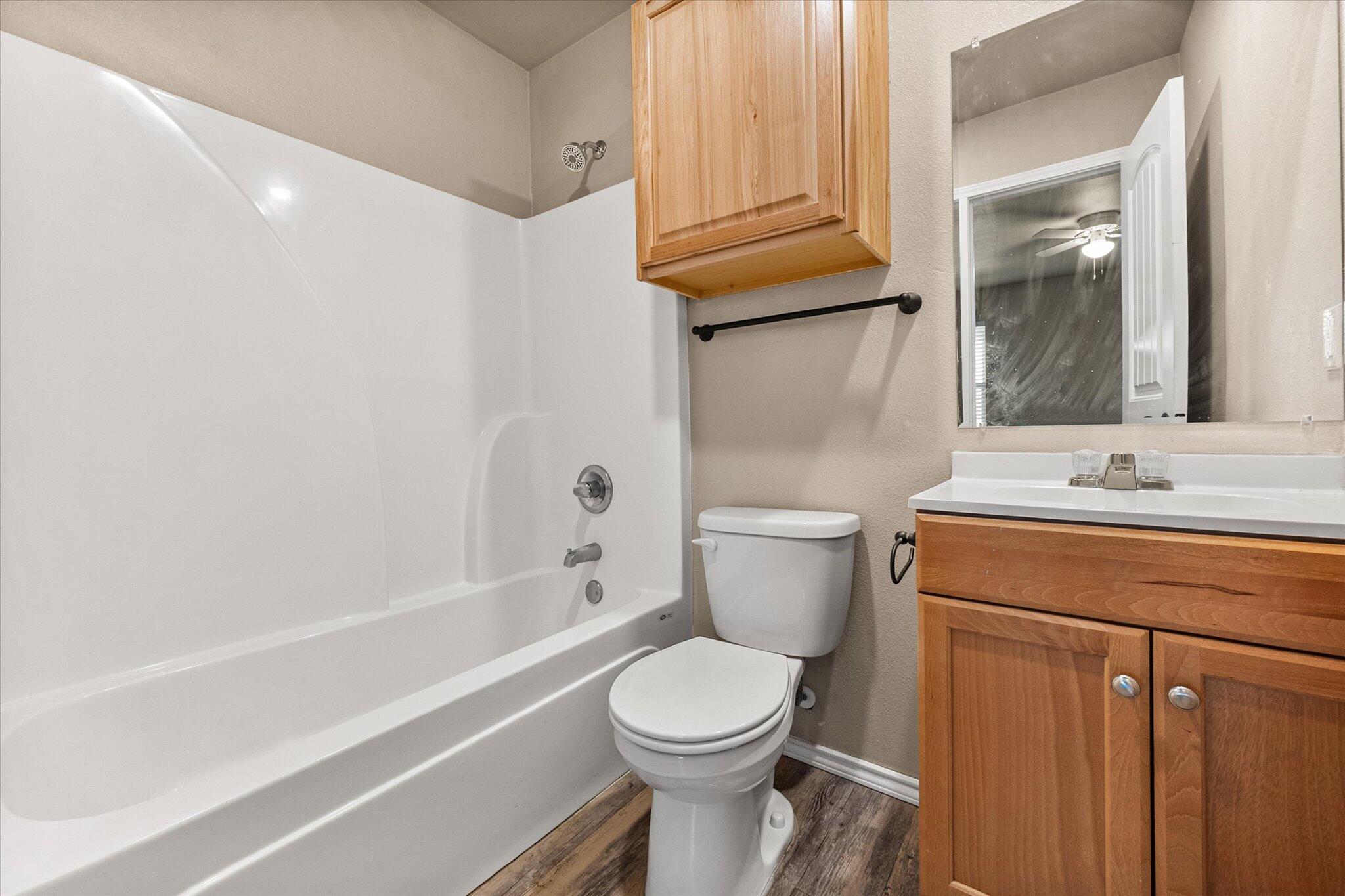 7412 5th Street, Unit 1 Lubbock, TX 79416 - Photo 14 of 16 a bathroom with a sink a toilet and shower