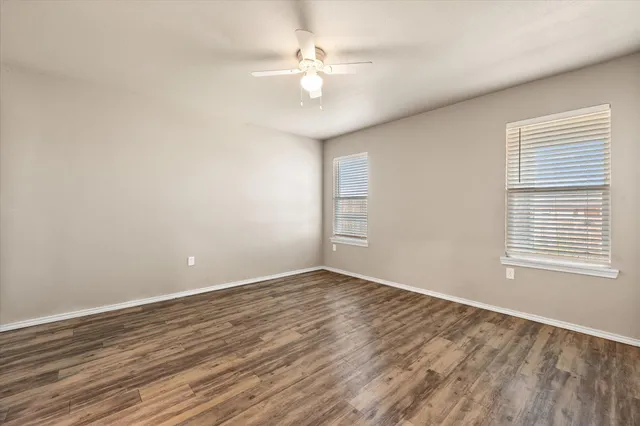 wooden floor in an empty room with a window