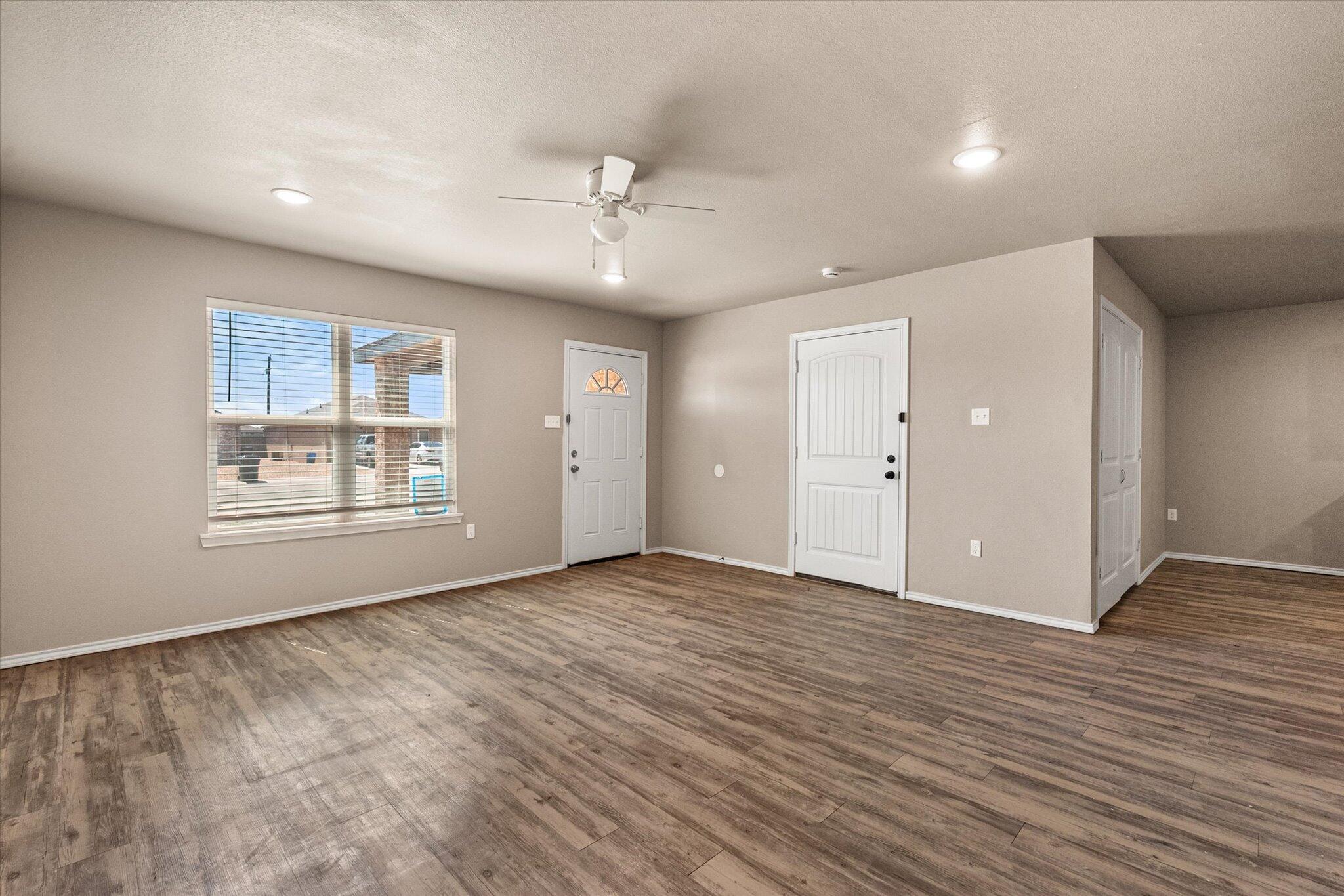 7412 5th Street, Unit 1 Lubbock, TX 79416 - Photo 4 of 16 a view of an empty room with a window and wooden floor