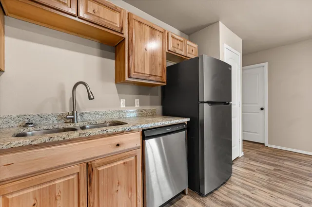 a kitchen with granite countertop a refrigerator and a sink