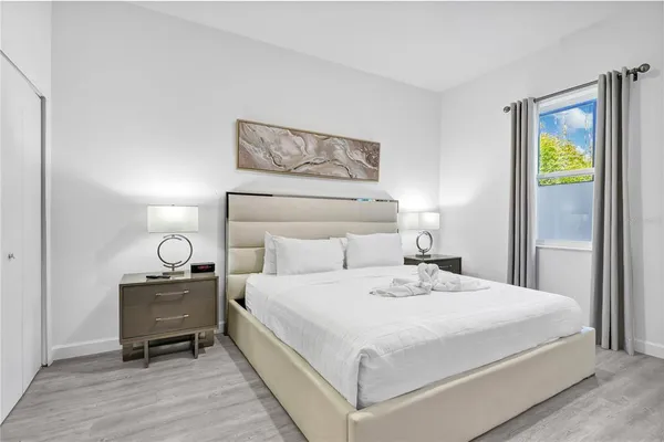 a bedroom with a bed and painting on the wall