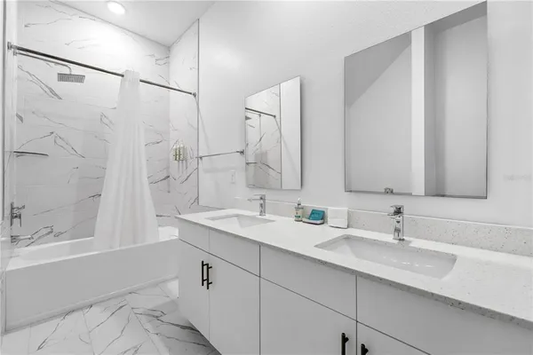 a bathroom with a double vanity sink mirror double and bathtub