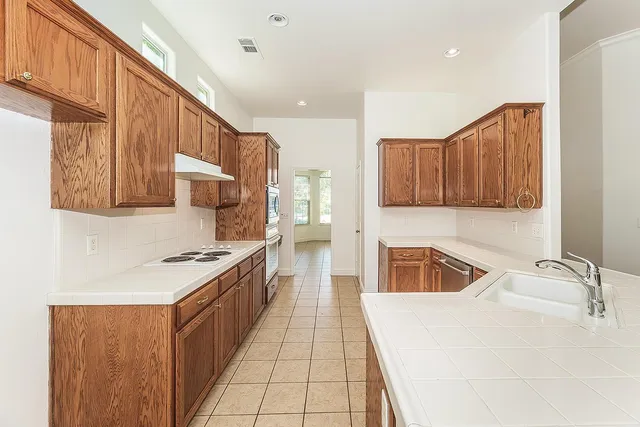 a kitchen with stainless steel appliances granite countertop a sink and a stove