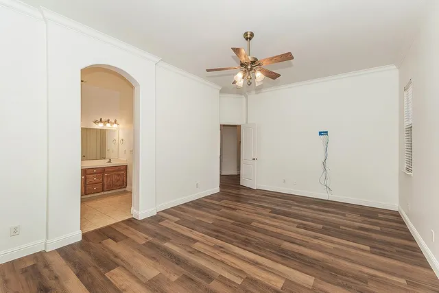 an empty room with a bathroom and a ceiling fan