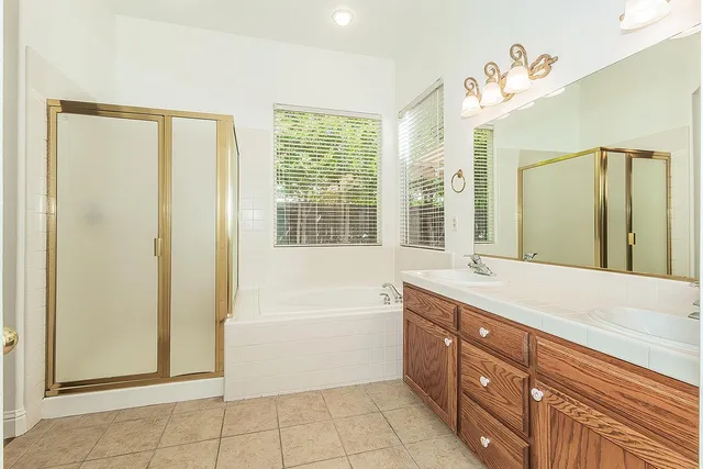 a spacious bathroom with a tub sink and mirror