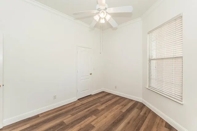 an empty room with a window and a fan