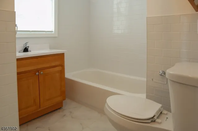 a bathroom with a granite countertop toilet and a sink