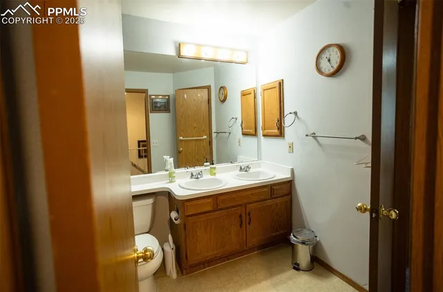 a bathroom with a sink a toilet a mirror and vanity