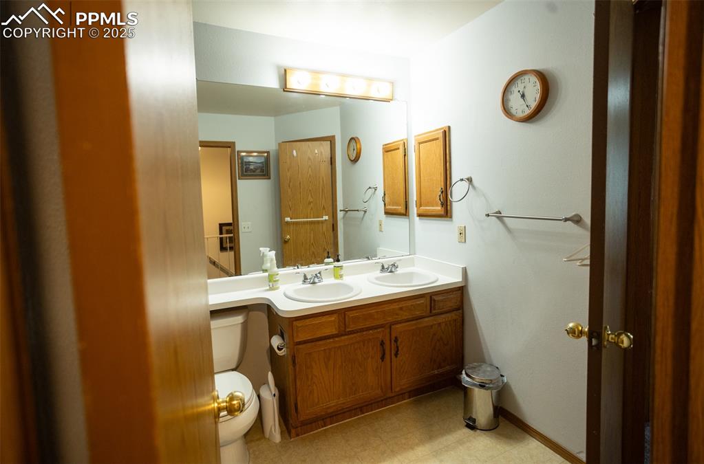 3515 Queen Anne Way Colorado Springs, CO 80917 - Photo 24 of 33 a bathroom with a sink a toilet a mirror and vanity