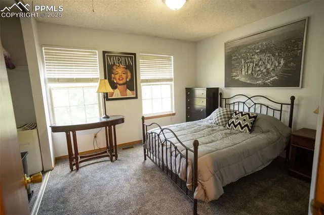 a bedroom with a bed a dresser next to a window