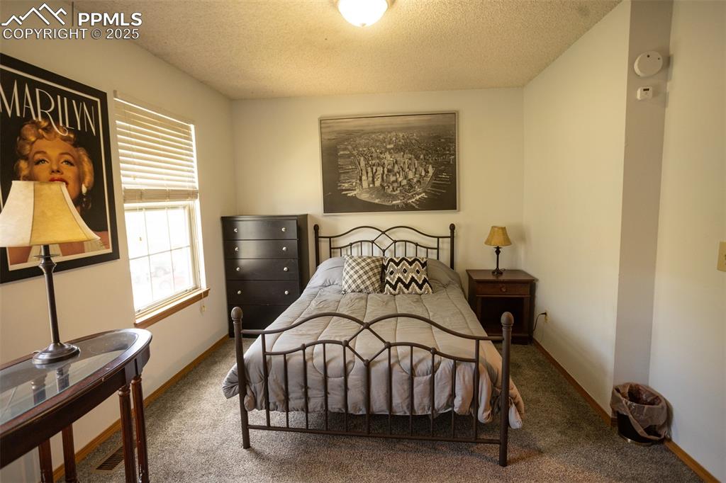 3515 Queen Anne Way Colorado Springs, CO 80917 - Photo 27 of 33 a bedroom with a bed and wooden floor