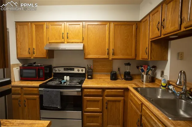 a kitchen with a sink a stove and cabinets