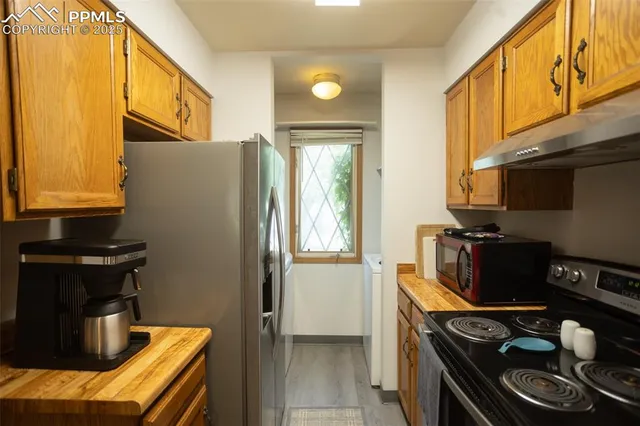 a kitchen with stainless steel appliances granite countertop a stove and a refrigerator
