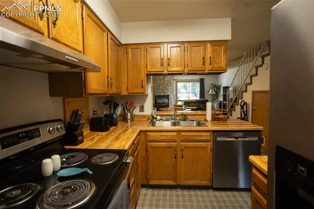 a kitchen with a sink a stove and cabinets
