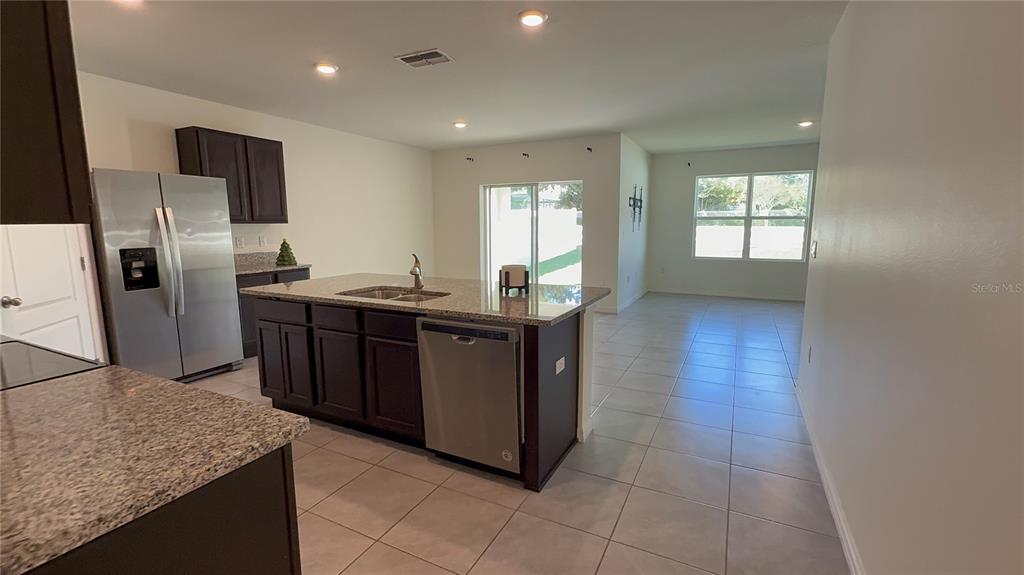 611 Autumn Stream Drive Auburndale, FL 33823 - Photo 5 of 30 a kitchen with stainless steel appliances granite countertop a sink counter space and refrigerator