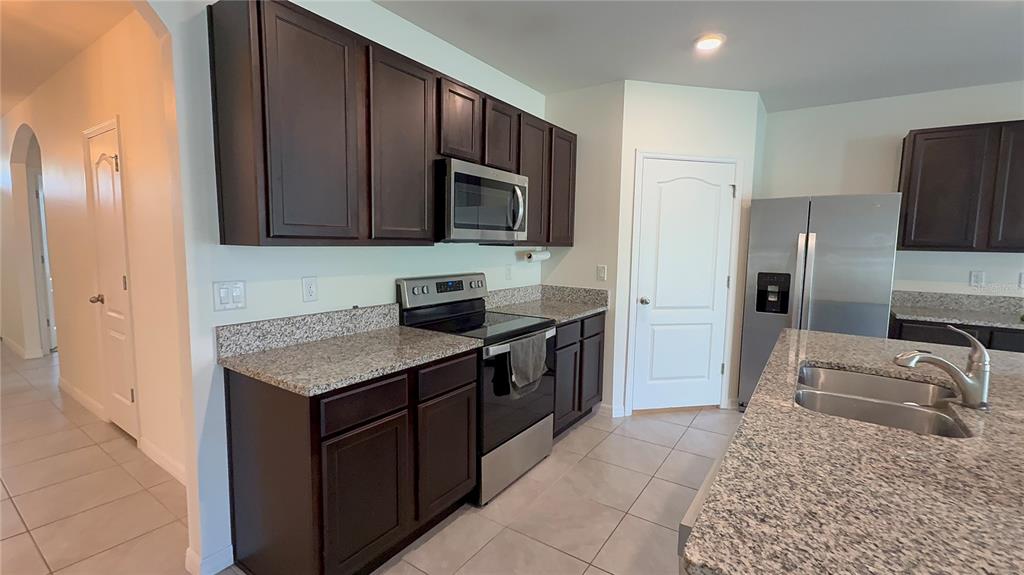 611 Autumn Stream Drive Auburndale, FL 33823 - Photo 8 of 30 a kitchen with stainless steel appliances granite countertop a refrigerator and a sink