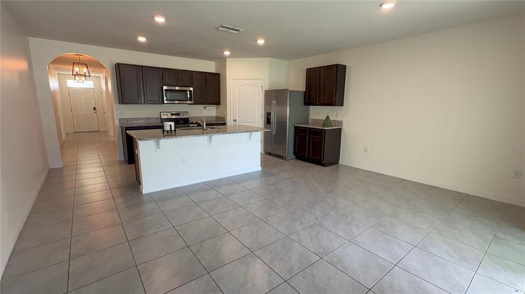 611 Autumn Stream Drive Auburndale, FL 33823 - Photo 10 of 30 a kitchen with stainless steel appliances a refrigerator sink and microwave
