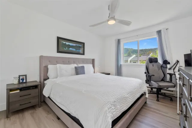 a bedroom with a bed and a dresser next to a window