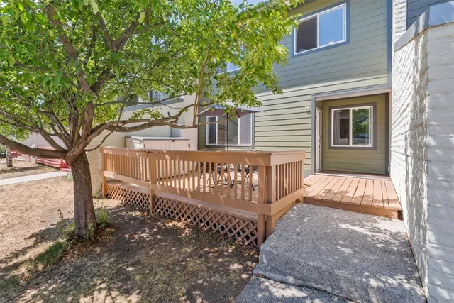 a view of a house with a small yard and wooden fence