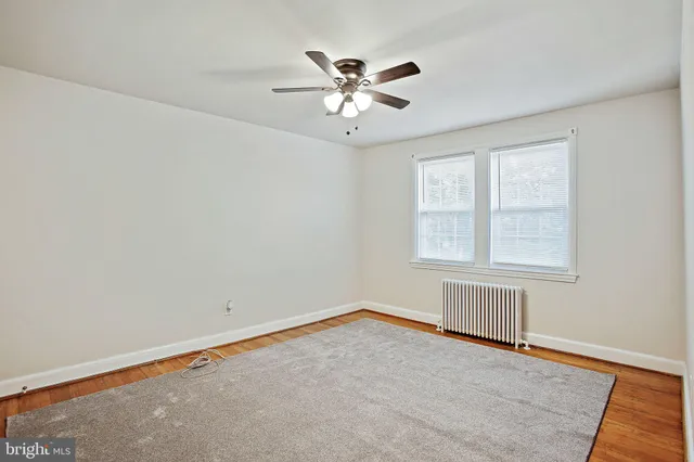 an empty room with a window and a ceiling fan