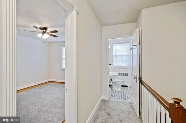a view of a hallway with a chandelier fan