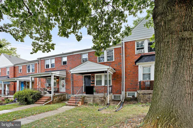 a front view of a building with large trees
