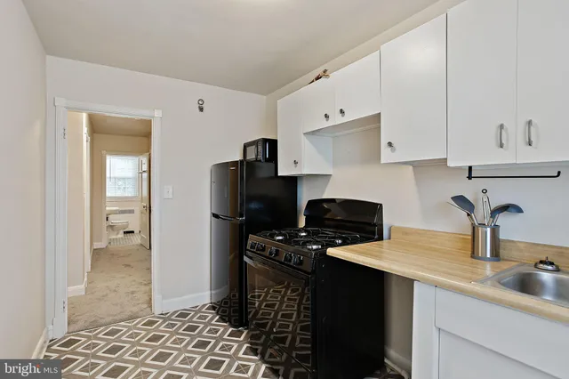 a kitchen with sink a refrigerator and cabinets