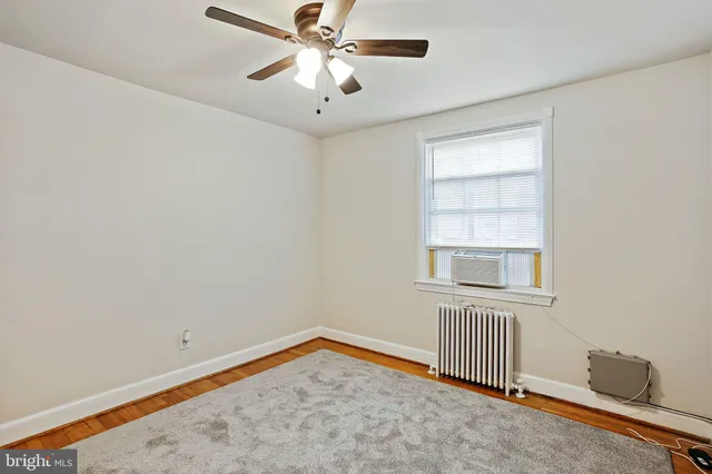 an empty room with a window and ceiling fan