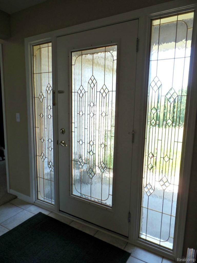 6340 Vassar Road Grand Blanc, MI 48439 - Photo 41 of 51 A custom leaded glass front door invites occupants and guests alike into this custom home. Tile flooring in foyer makes for case of maintenance.