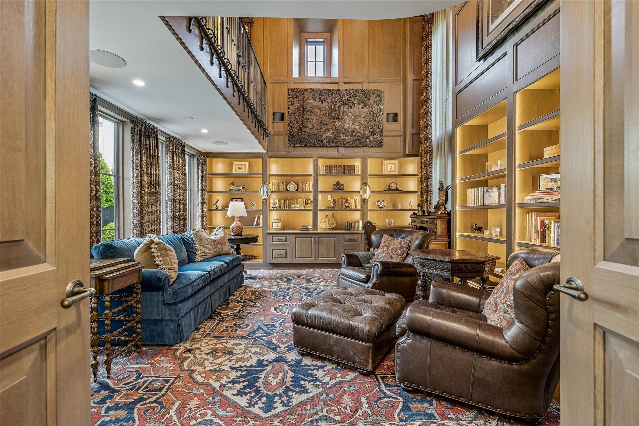 2158 Chilton Road Houston, TX 77019 - Photo 6 of 50 A striking two-story library sets the tone with vaulted beamed ceilings, rich paneling, and backlit built-ins. Dual exposures fill the space with natural light, creating a warm yet dramatic retreat.