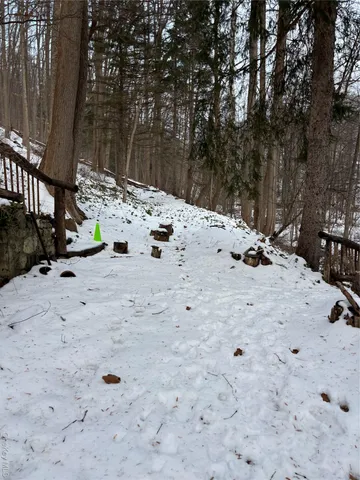 a view of white house with a yard covered in snow