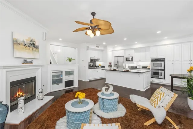 a living room with furniture kitchen view and a fireplace