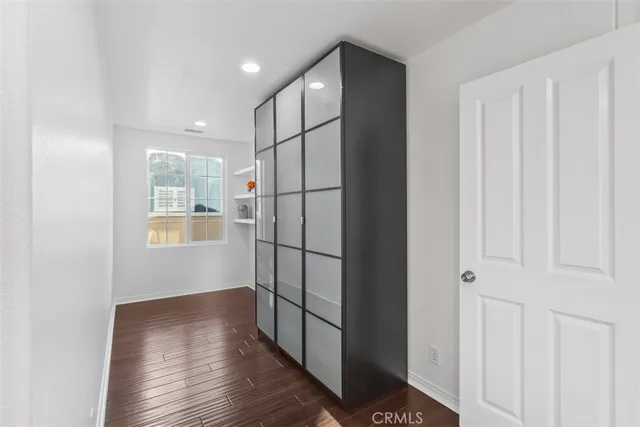 a view of a hallway with cabinet and mirrors