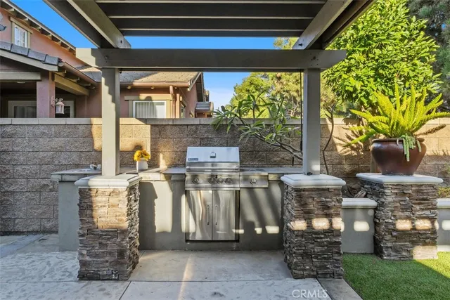a view of a chairs and table in patio with a barbeque