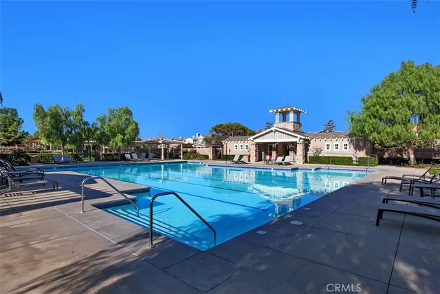 a swimming pool with outdoor seating and a garden