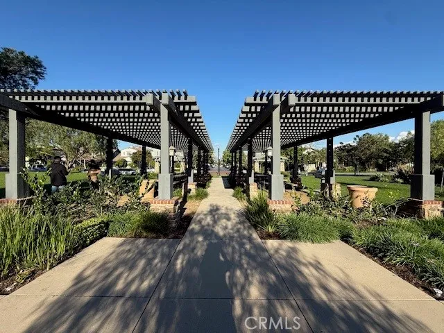 a view of a patio with table and chairs potted plants and floor to ceiling window