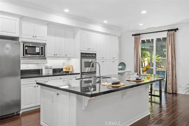 a kitchen with kitchen island granite countertop a sink stove and cabinets