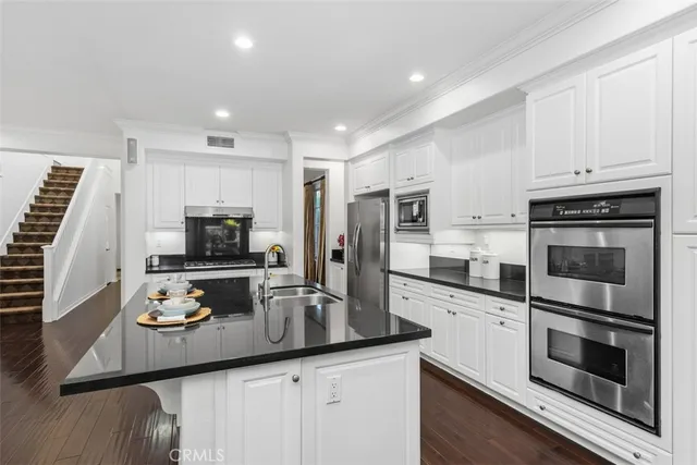 a kitchen with granite countertop stainless steel appliances and a counter space