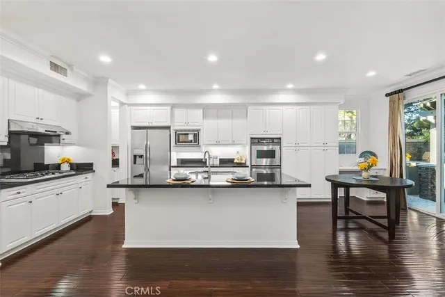 a kitchen with stainless steel appliances a white stove top oven a sink dishwasher and a refrigerator