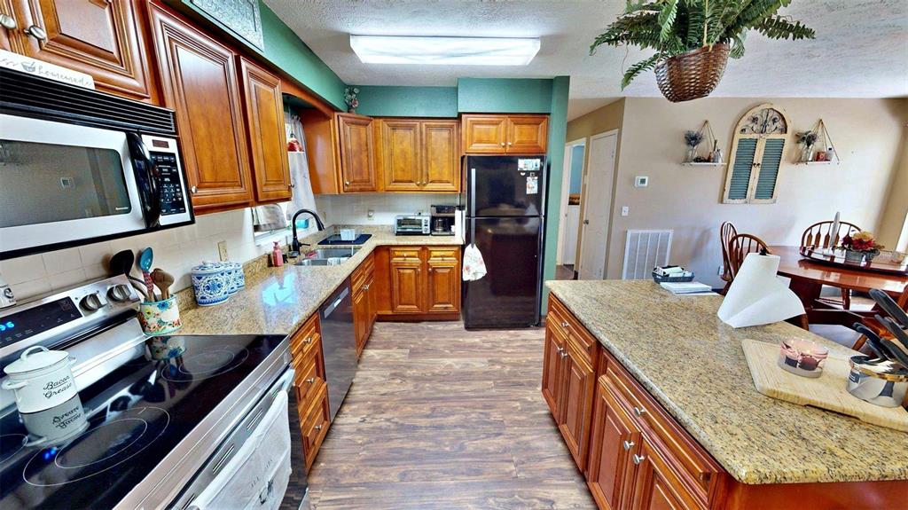 635 Bost Road Wauchula, FL 33873 - Photo 10 of 39 a kitchen with stainless steel appliances granite countertop a sink stove and refrigerator