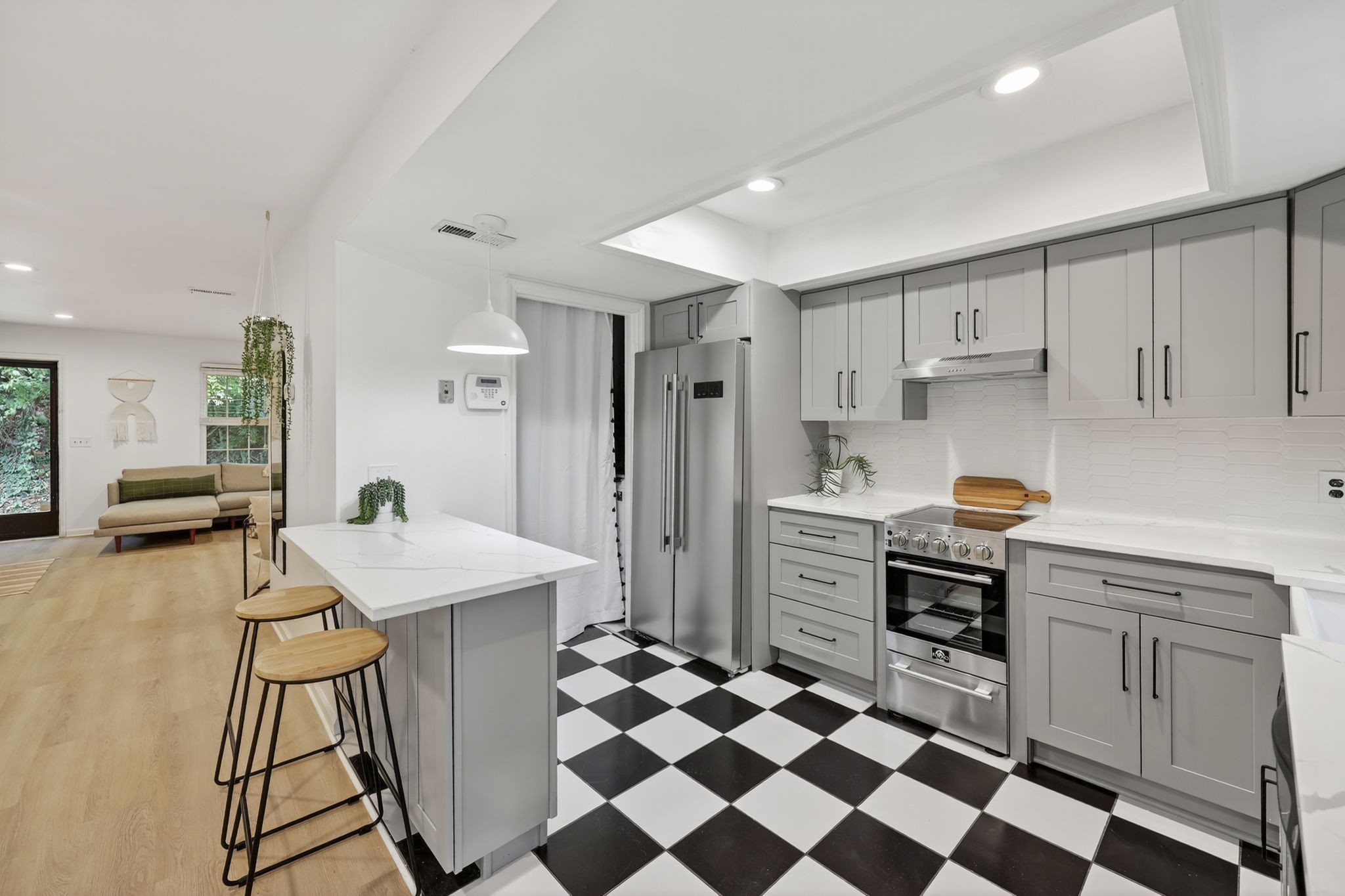 a kitchen with stainless steel appliances a stove a sink and a refrigerator with white cabinets