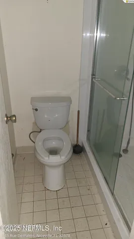 a white toilet sitting next to a shower