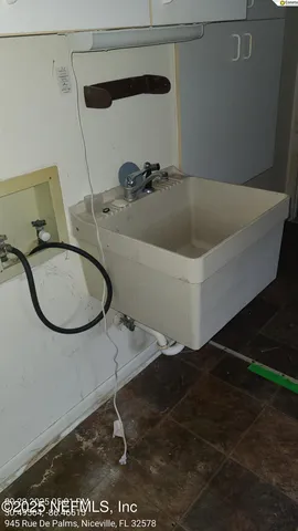 a view of a backyard with large trees and wooden fence