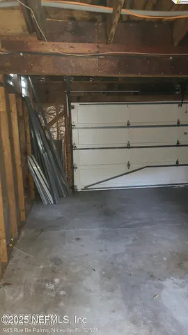 a view of a backyard with large trees and wooden fence