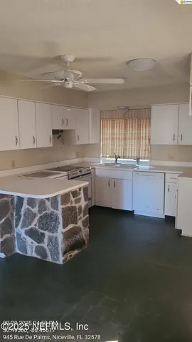 a kitchen with stainless steel appliances granite countertop a sink dishwasher a stove a dining table and chairs with wooden floor